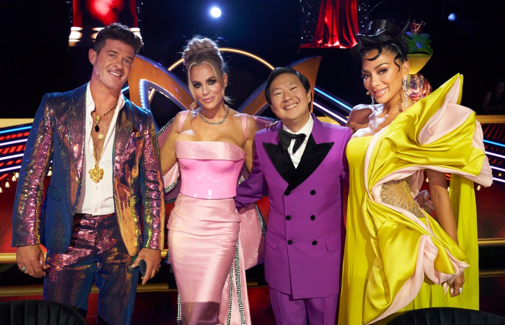 Robin Thicke, Jenny McCarthy, Ken Jeong and Nicole Scherzinger stand together smiling. 