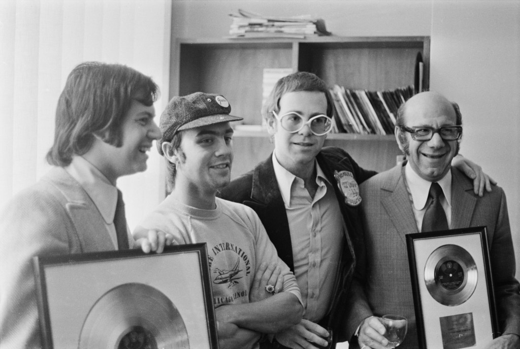 Stephen James, songwriter Bernie Taupin, singer and pianist Elton John, and Stephen's father, music publisher Dick James (L-R), in October 1972.  
