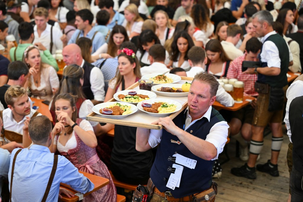 A person carries food to a table inside one of the dozens of tents at Oktoberfest on Sept. 16.