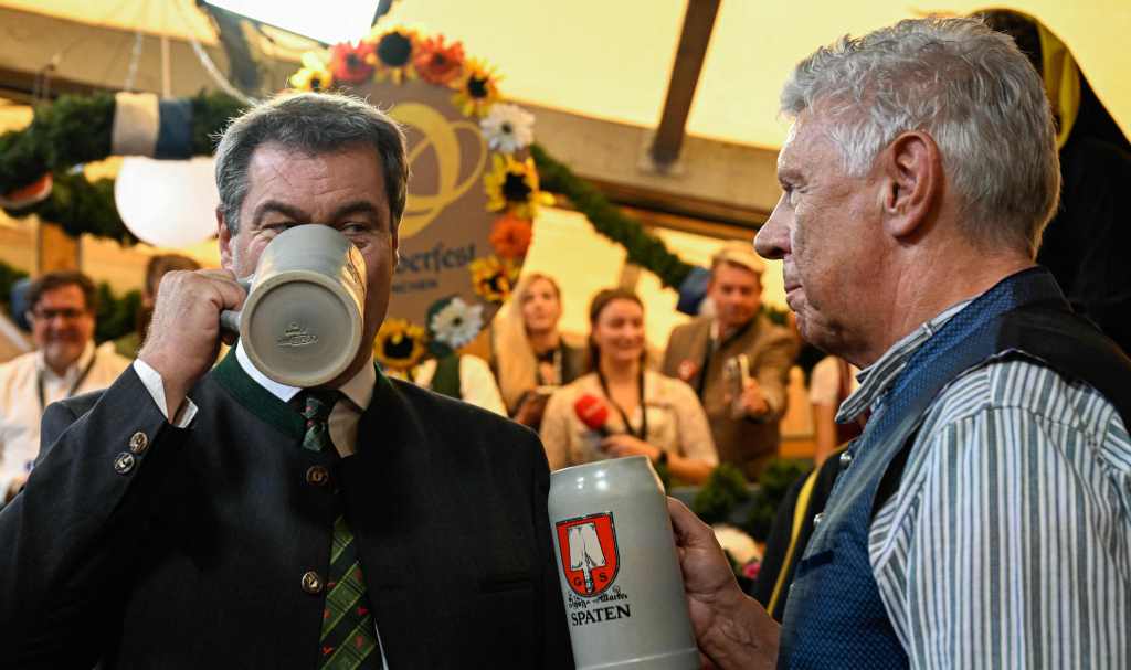 Reiter, right, and Bavaria's State Premier Markus Soeder drink from their beer mugs following the tapping of the first barrel.