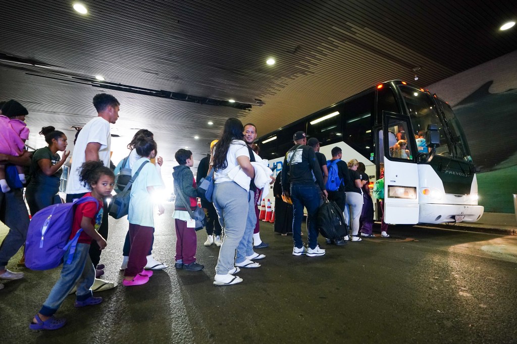 Migrants board a bus