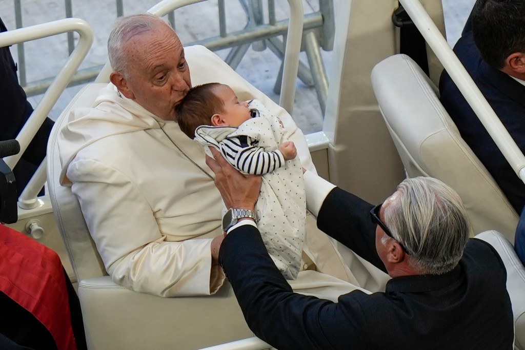 Pope Francis kisses a baby as he arrives at the "Velodrome Stadium", in Marseille, France