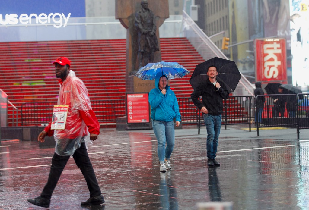 People walking with umbrellas in the rain in Times Square on September 23, 2023.