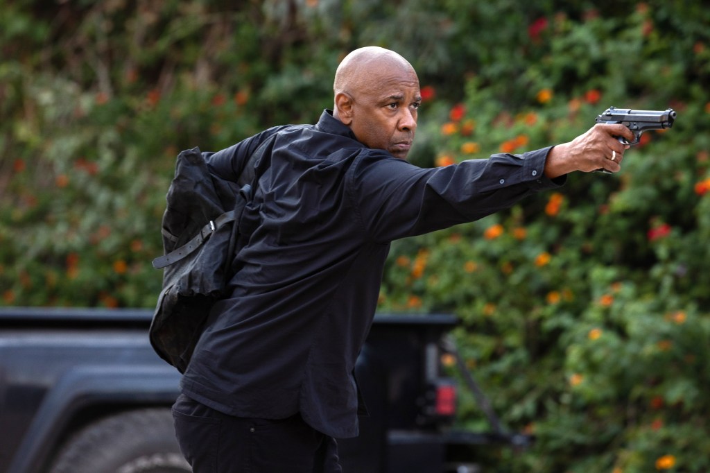 In a scene from "The Equalizer 3," Denzel Washington points a gun at someone off screen.