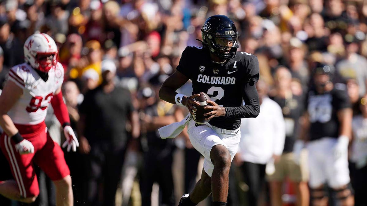 Shedeur Sanders runs with the football during a game