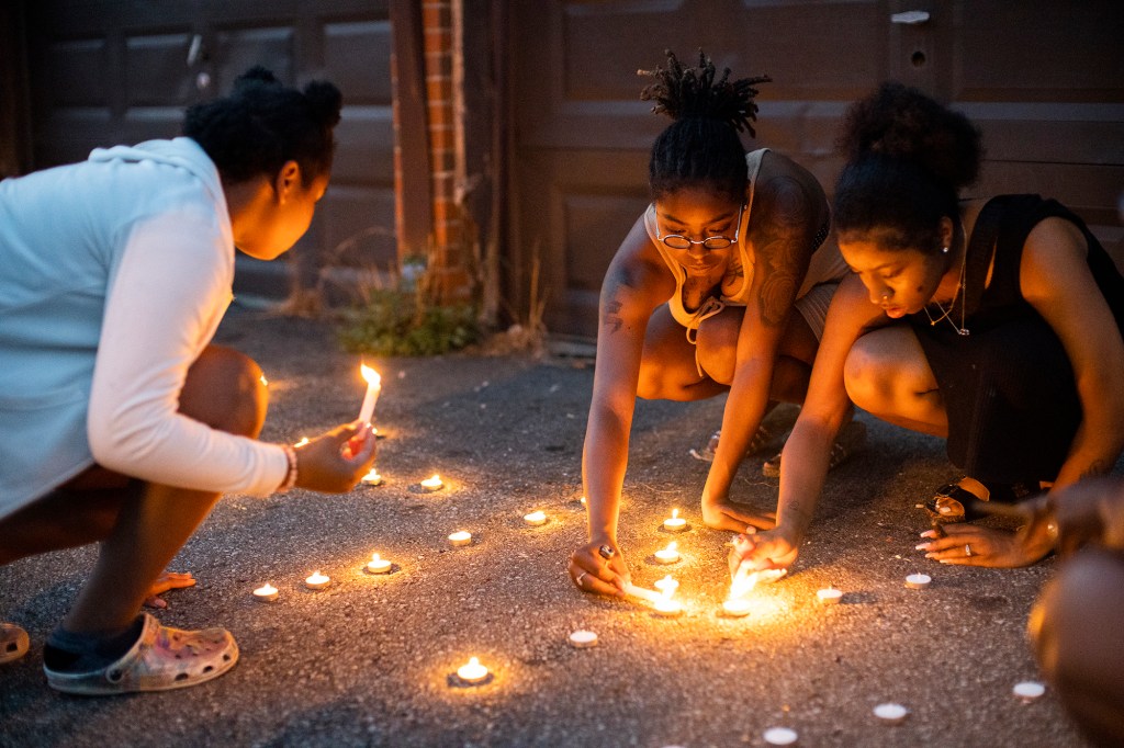 Friends and family of Ta'Kiya Young light candles that spell out "RIP Kiya" at her vigil on Aug. 25, 2023, in Columbus, Ohio. 