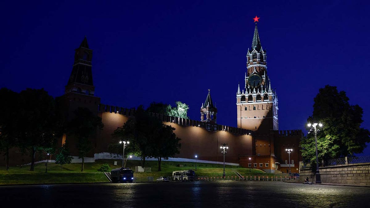 Law enforcement vehicles are seen in front of the Kremlin's Spasskaya Tower