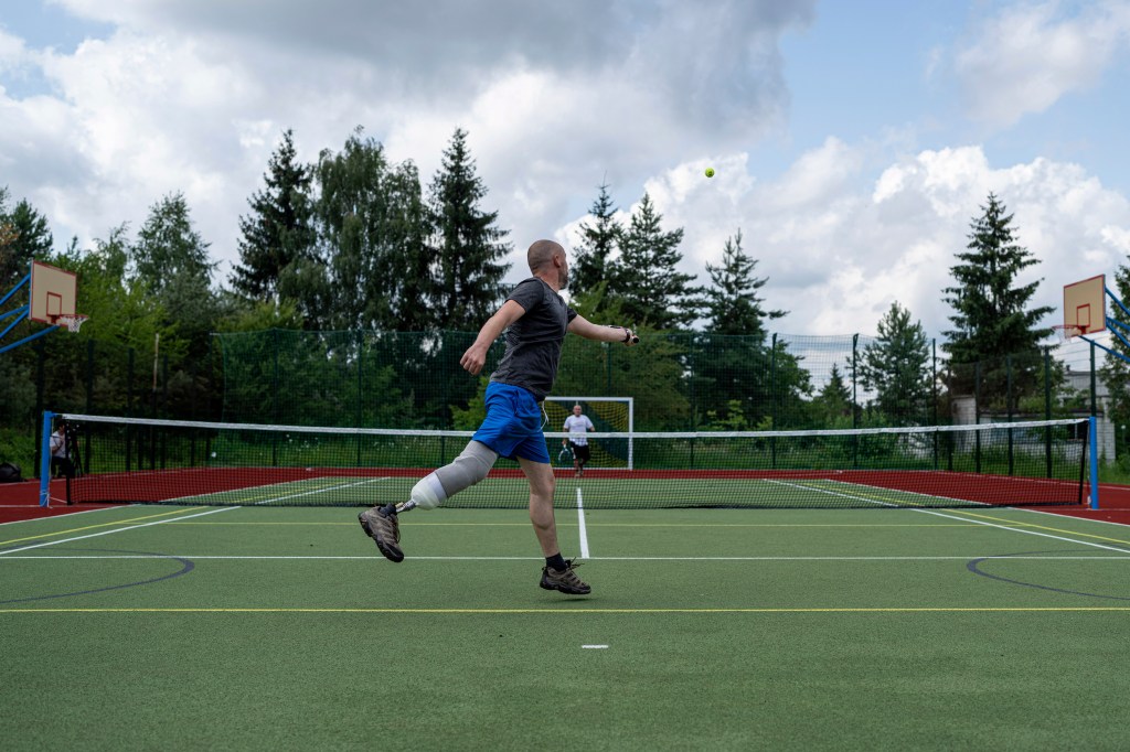 Wounded Ukrainian army veterans play tennis at a rehabilitation center in Vynnyky, Ukraine. 