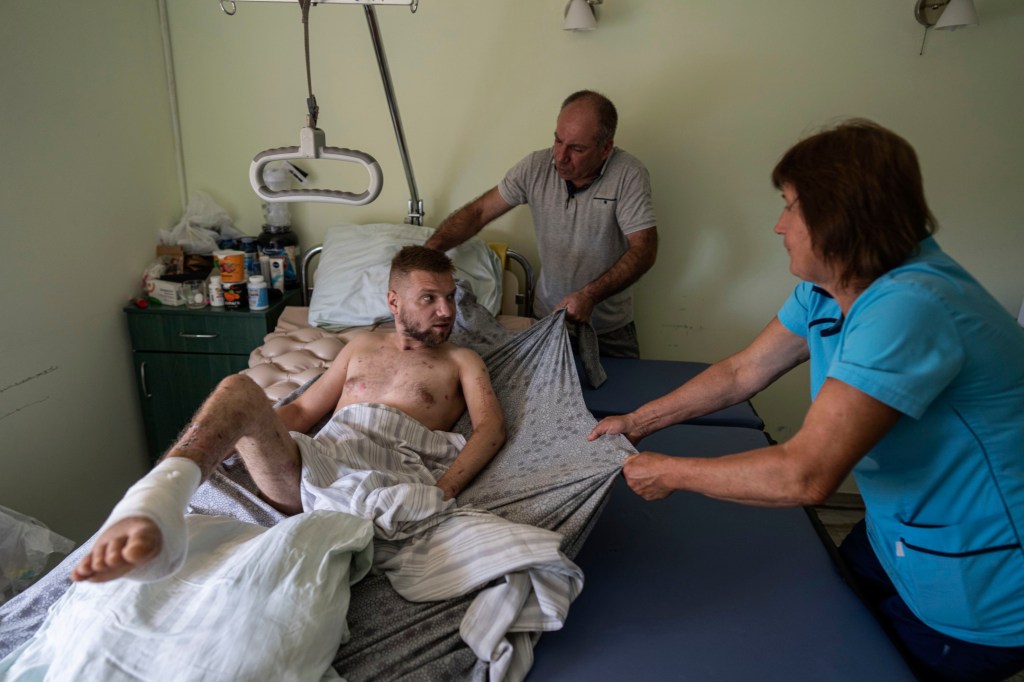 Medics transfer a soldier to a stretcher at St. Panteleimon hospital in Lviv, Ukraine, on July 25, 2023.