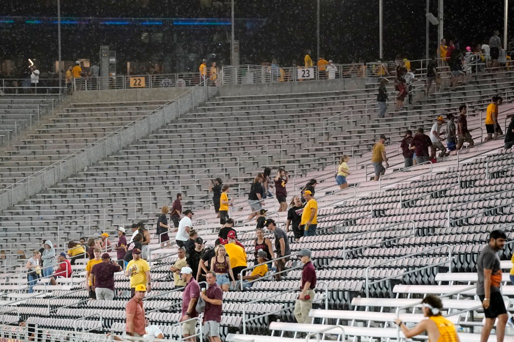 Fans exit the stadium during the weather delay at an NCAA college football game between Arizona State and Southern Utah on Aug. 31, 2023, in Tempe, Ariz. 