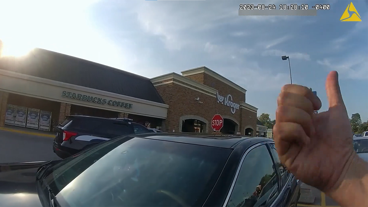 An officer's hand gesturing to exit the vehicle