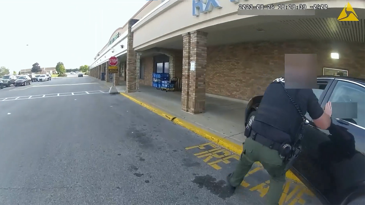 One officer running after the car