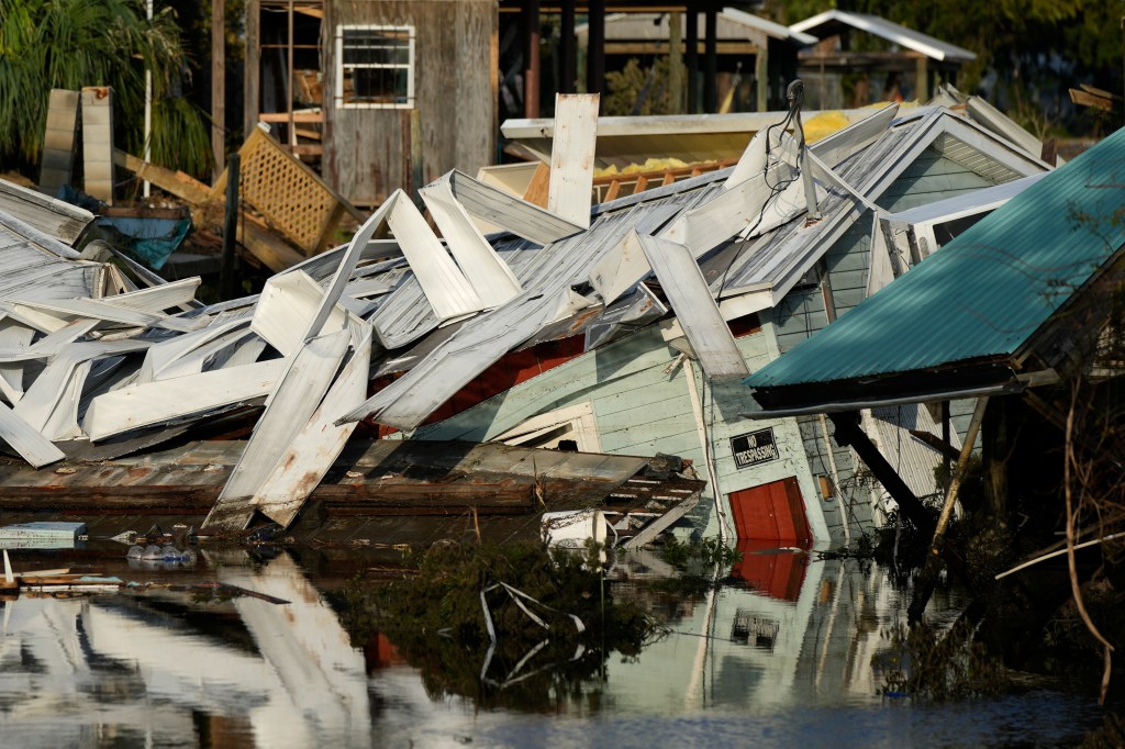 An unstilted home which came off its blocks sits partially submerged in a canal, in Horseshoe Beach, Fla., on Sept. 1, 2023. 