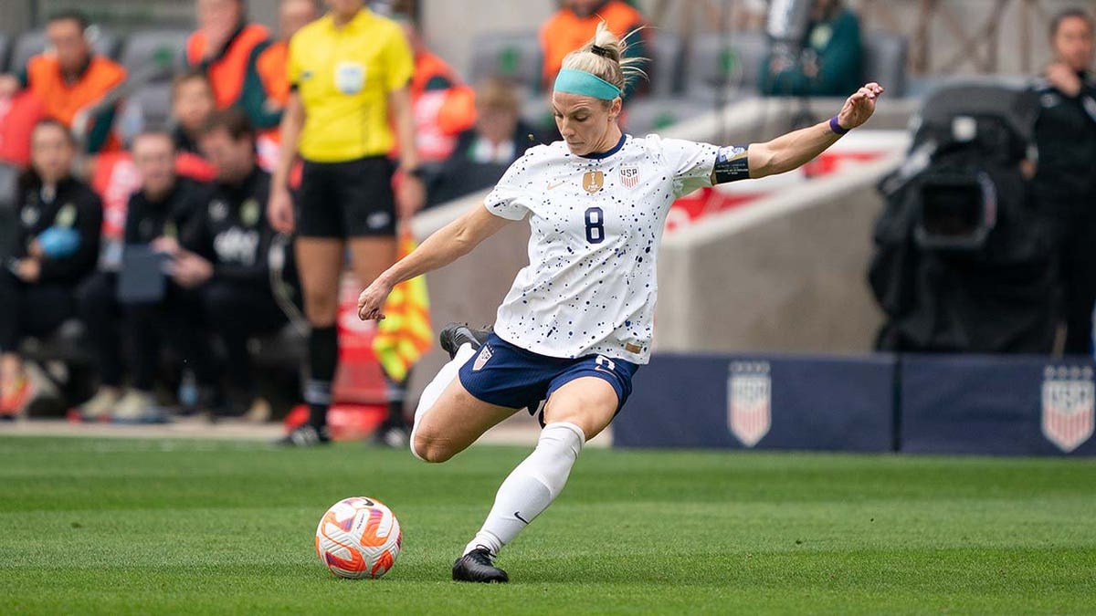 Julie Ertz kicks a soccer ball