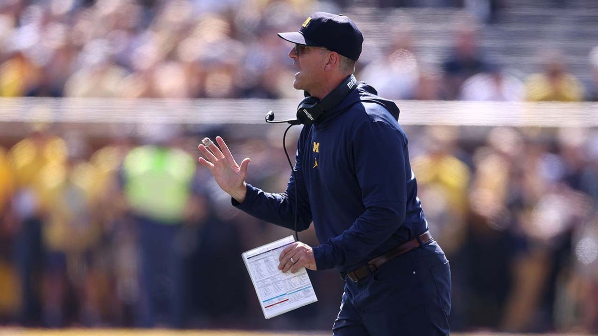 Jim Harbaugh coaches during the first half