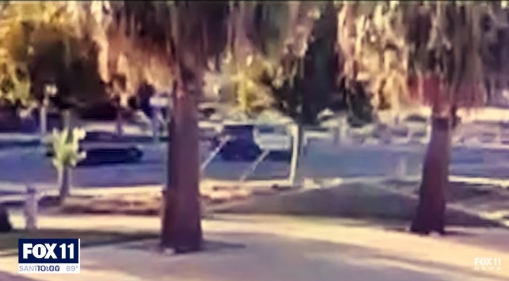 In a security video released by Fox 11, a black car is seen pulling up next to the deputies patrol car moments before it's believed he was senselessly shot.