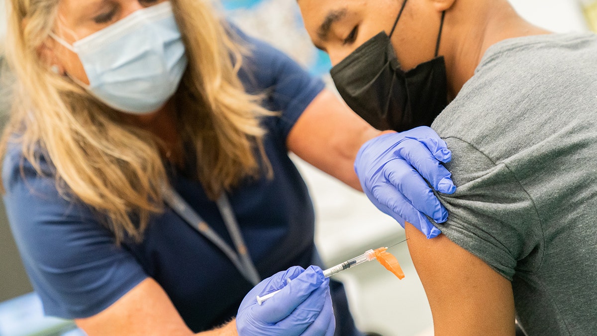 A NYC healthcare worker administers a COVID-19 shot