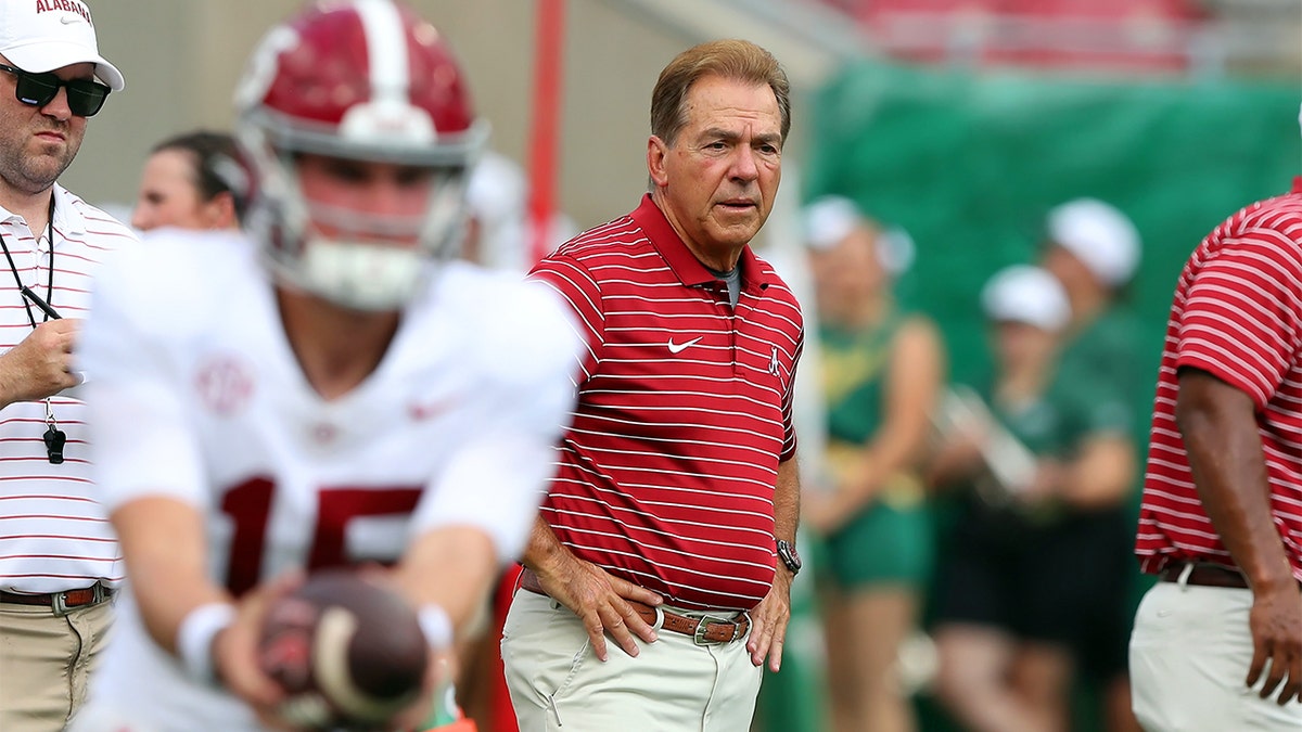 Nick Saban watches his team warm up