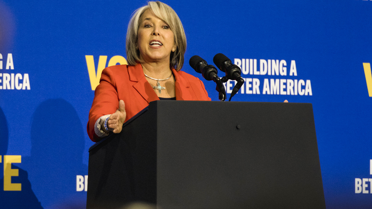 Lujan Grisham speaking with blue background behind her