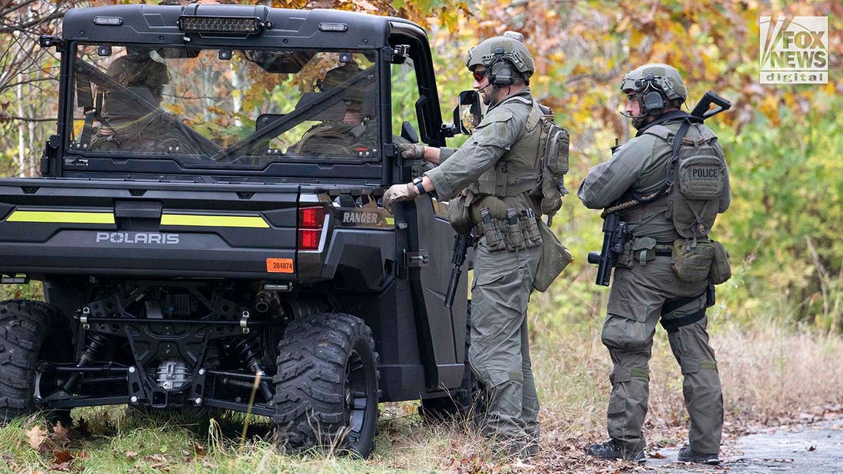 Law enforcement agents aid in the search for Robert Card along the Androscoggin River