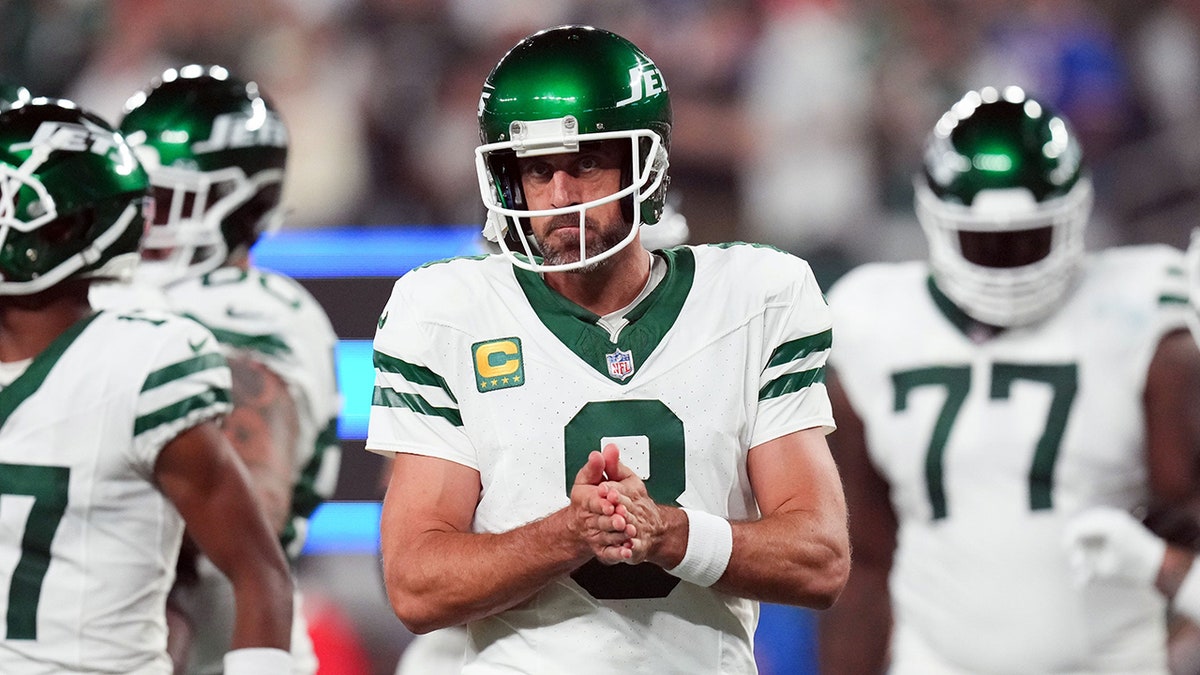 Jets quarterback Aaron Rodgers huddles