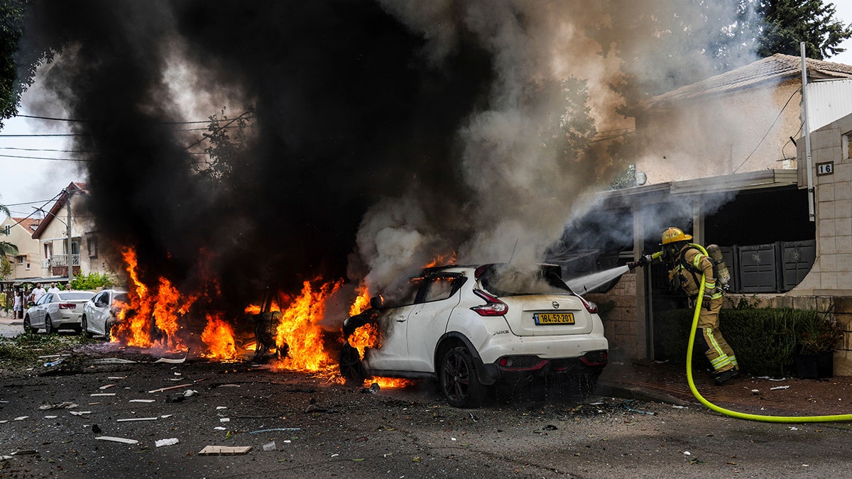 firefighter puts out car fire