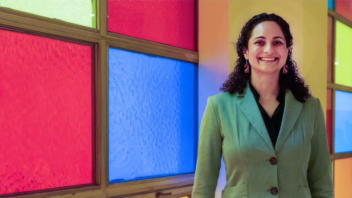 Samantha Woll standing in front of stained glass windows.