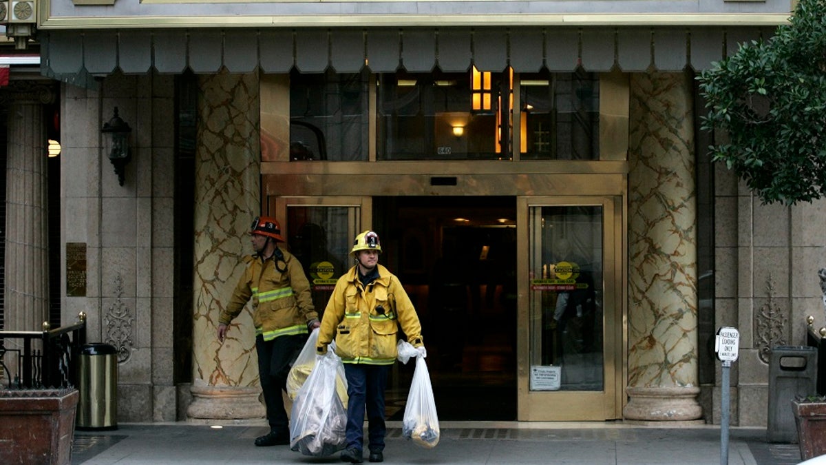 fighterfighters removing a body outside the Cecil Hotel