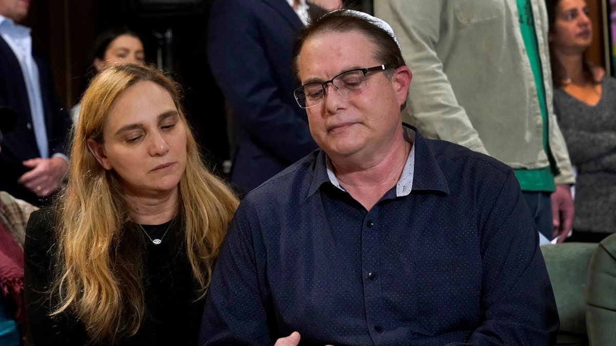 Sigal Zamir, left, and her husband Avi holds hands as they attend a prayer vigil for Judith Raanan and her daughter Natalie on Thursday, Oct. 12, 2023, in Evanston, Ill