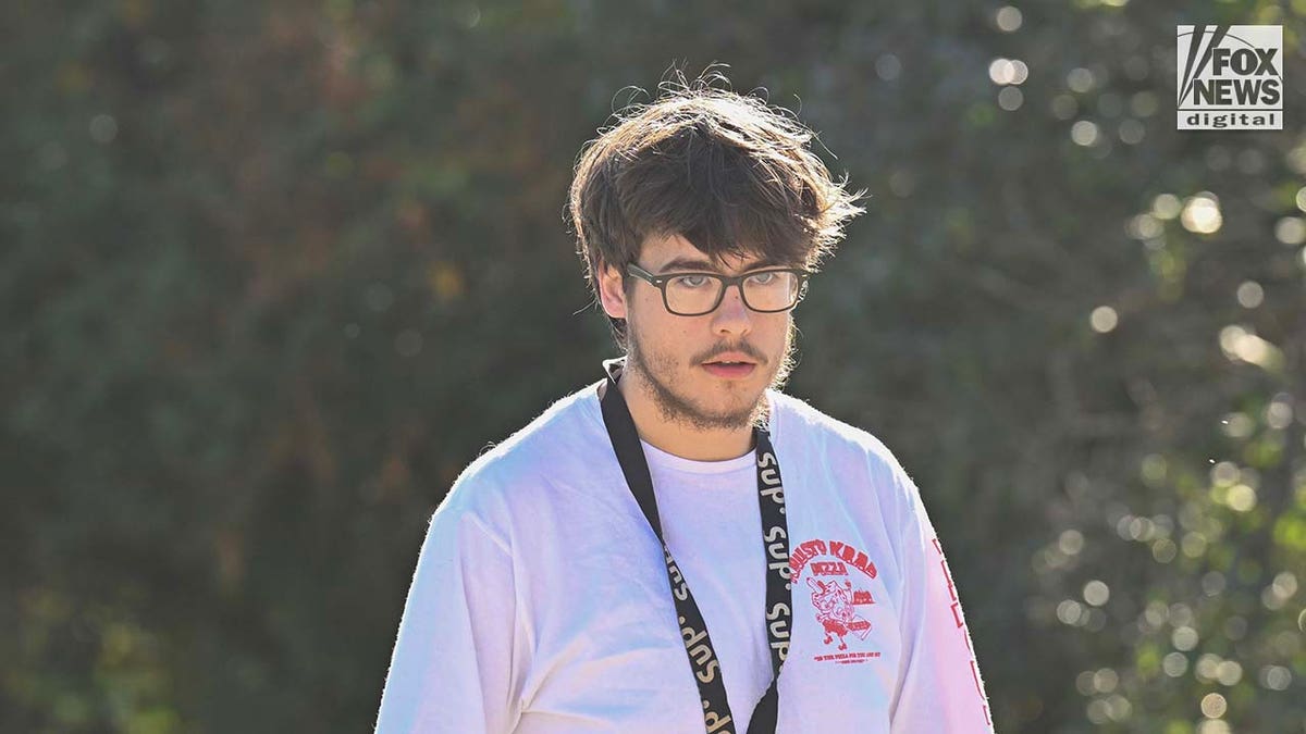 Son of Craig Ross Jr wearing glasses and a lanyard around his neck