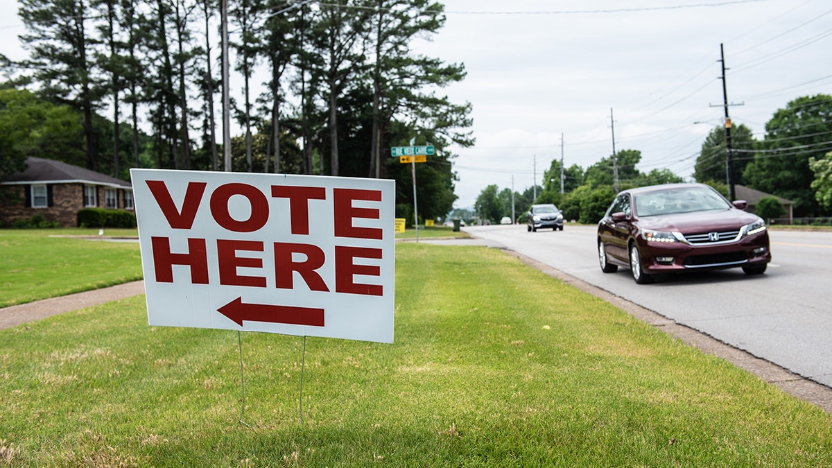 sign telling people to 'vote here'