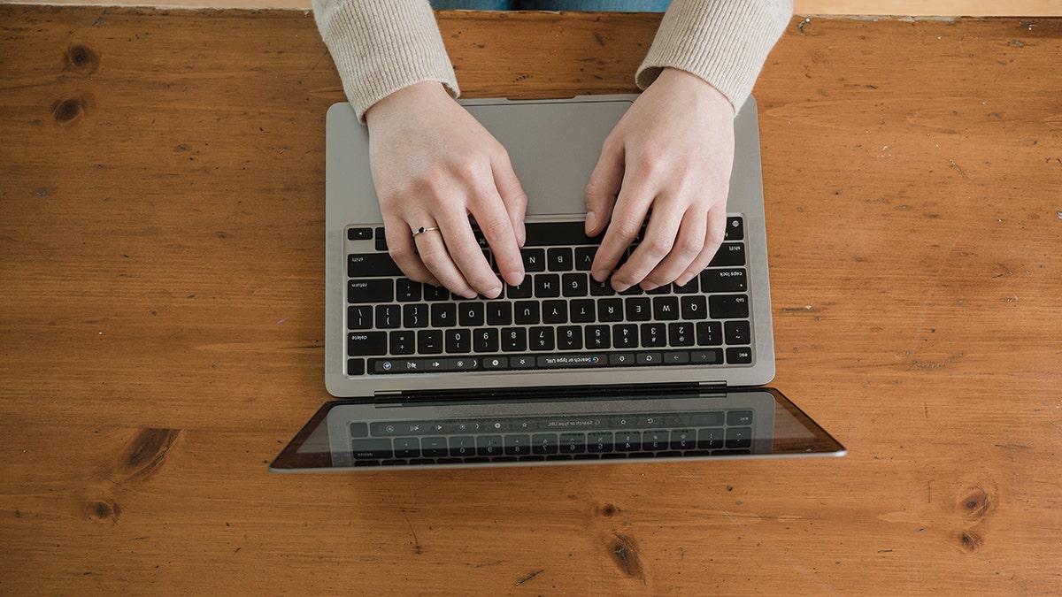 Someone typing on a laptop