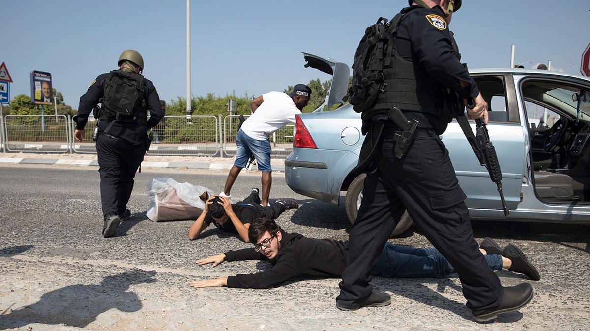 Police officers check a suspect at border checkpoint