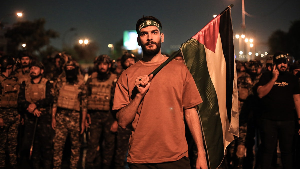 Palestine flag and protesters outside US embassy in Baghdad