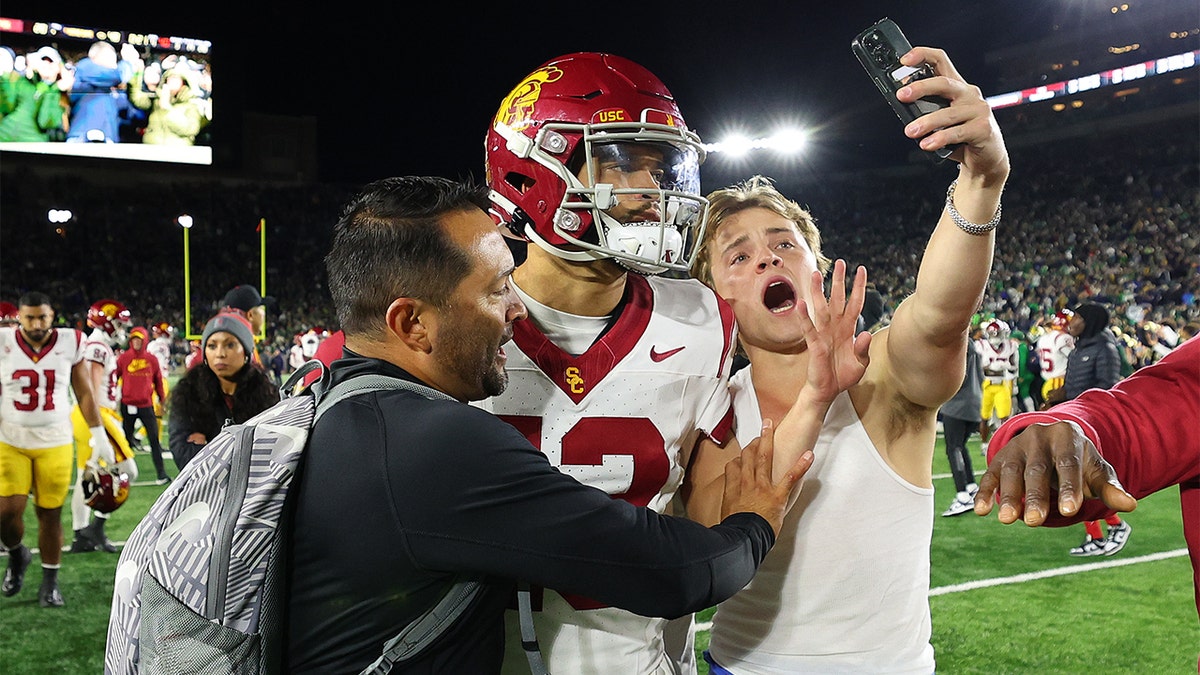 A fan rushes Caleb Williams after the game