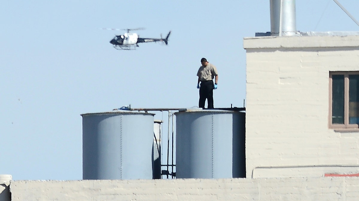 A worker standing on a water tank outside