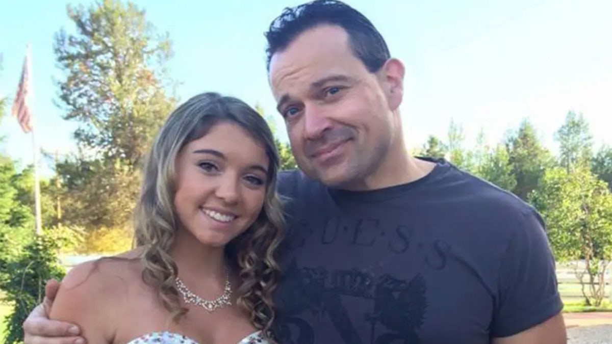 Steve and Kaylee Goncalves pose in front of trees.