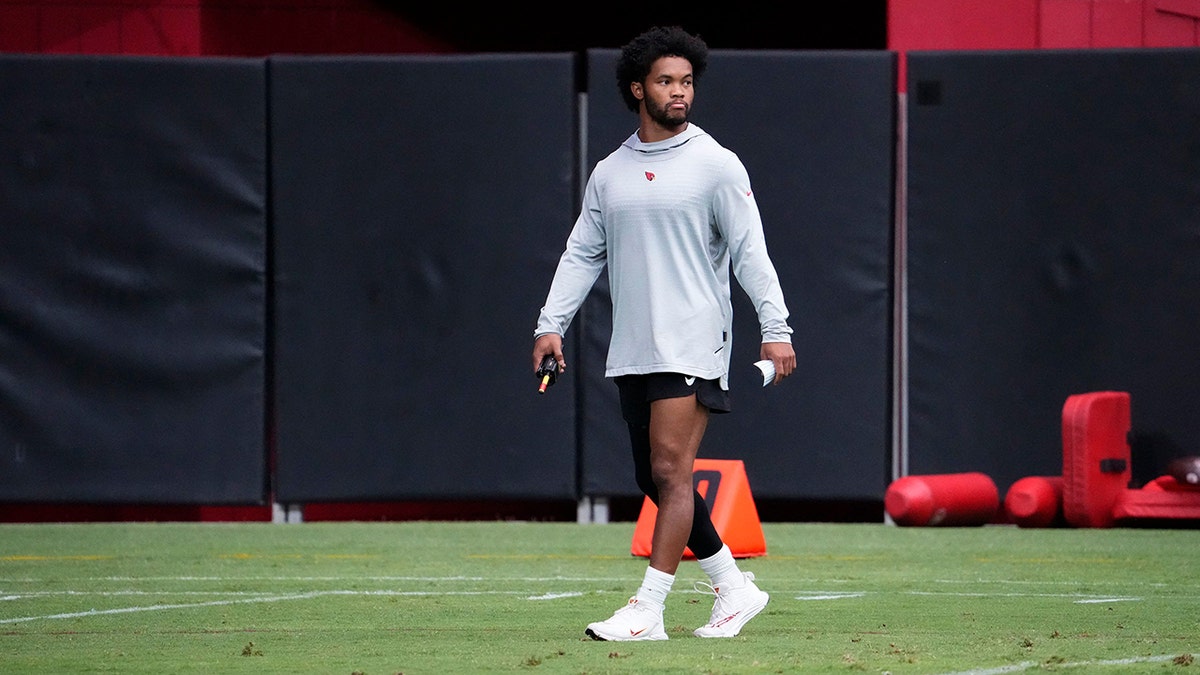 Arizona Cardinals quarterKyler Murray walks around the field during training camp