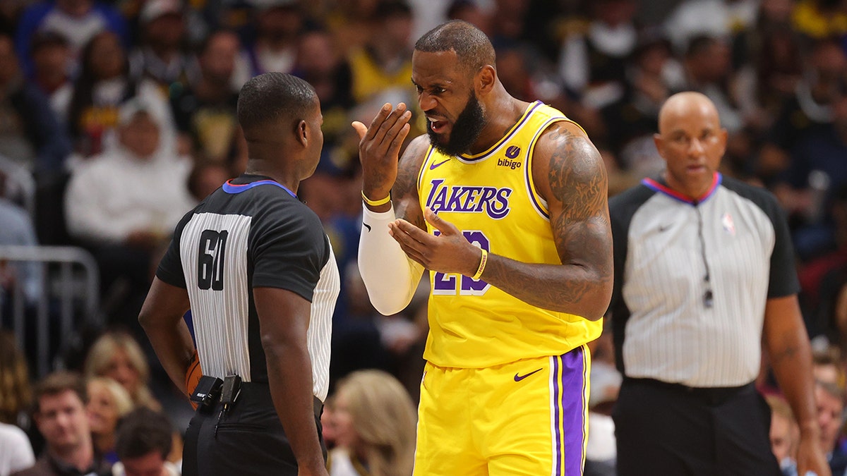 LeBron James speaks with referee