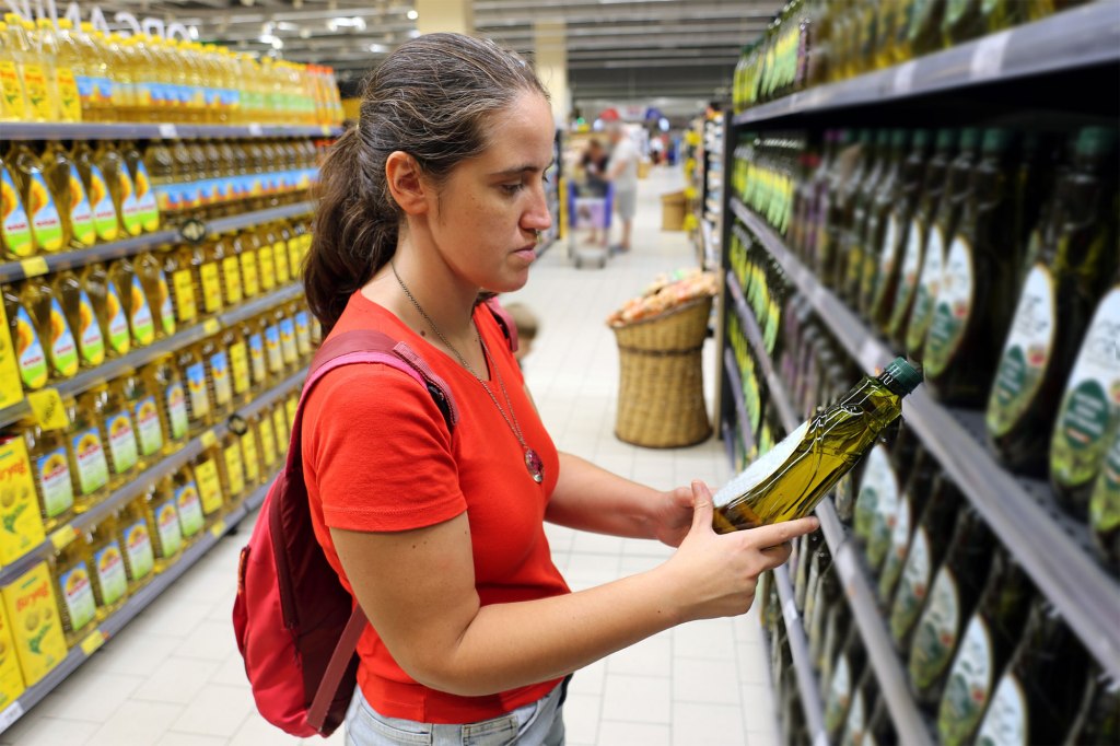 A woman shopping for olive oil. 