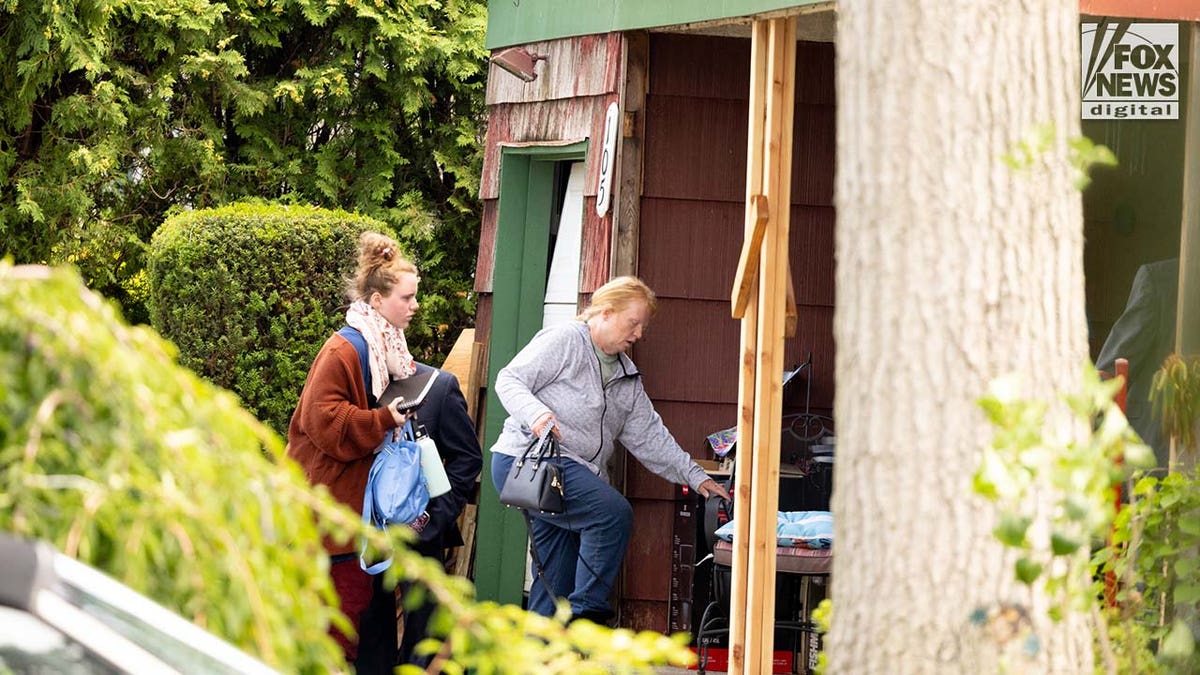 Asa Ellerup and Victoria Heuermann enter their home in Long Island