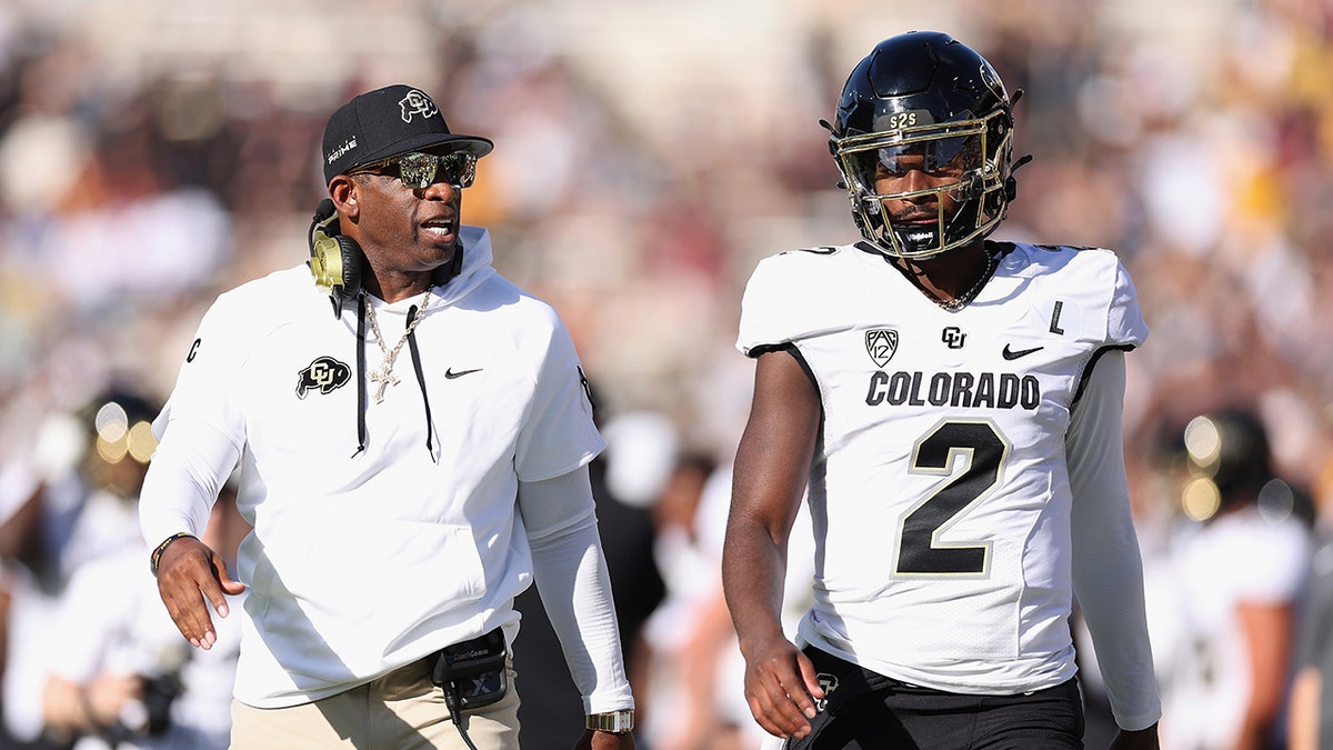 Deion Sanders and Shedeur Sanders walk on field