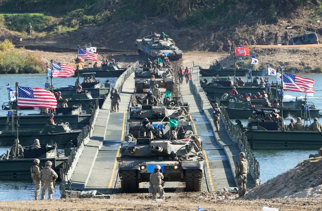 South Korean Army K1E1 tanks cross a floating bridge on the Namhan River during a joint river-crossing drill between South Korea and the United States in Yeoju, South Korea, Friday, Oct. 20, 2023.