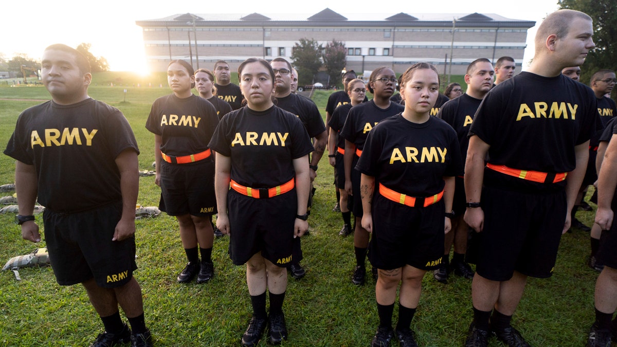 soldiers in black PT uniforms on field