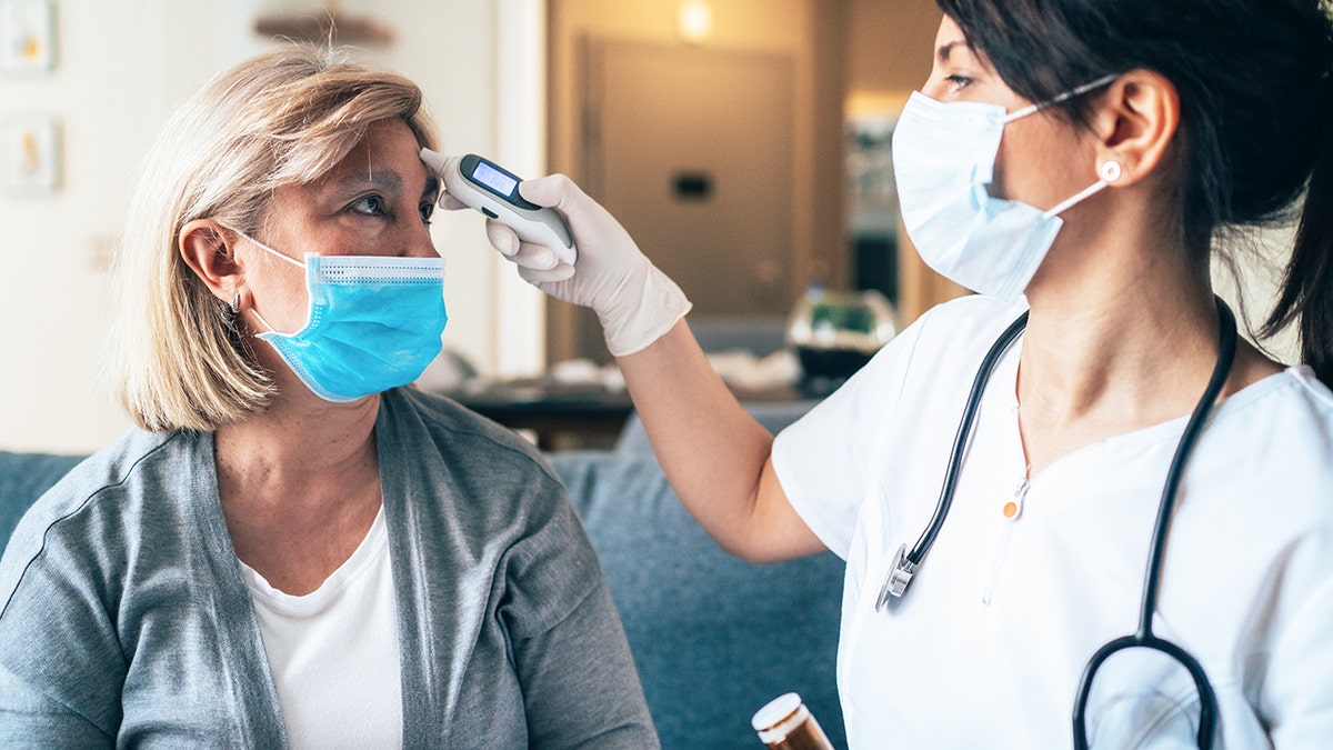 Woman getting temperature taken