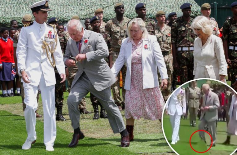 King Charles trips on fake cemetery grass as Camilla watches