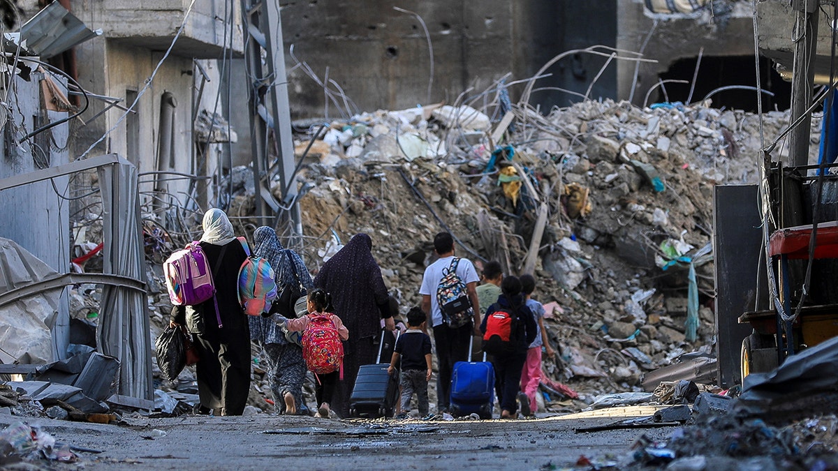 Palestinians carry their belongings as they flee their houses