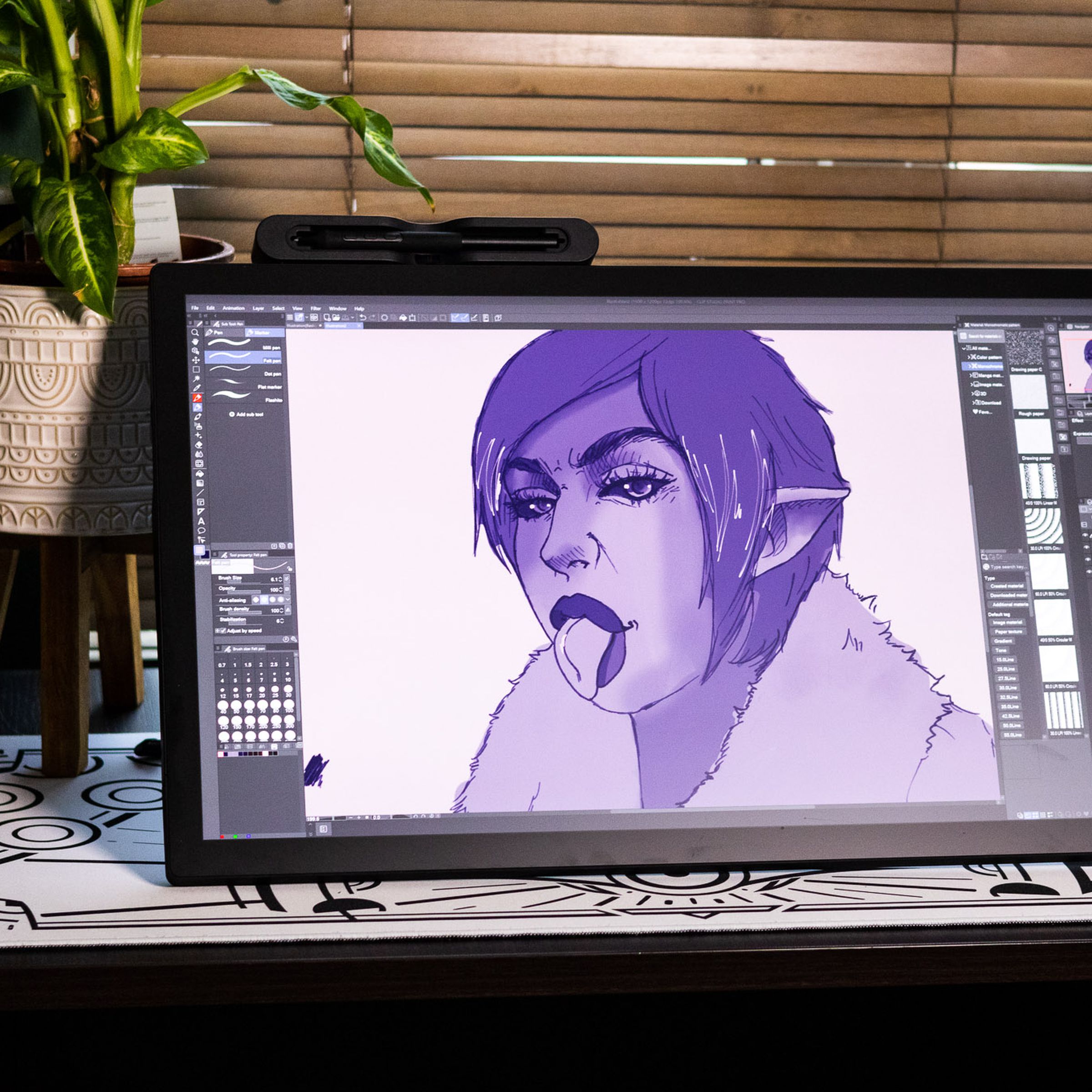 The Wacom Cintiq Pro 27 Creative Pen Display on a desk, displaying a purple illustration.