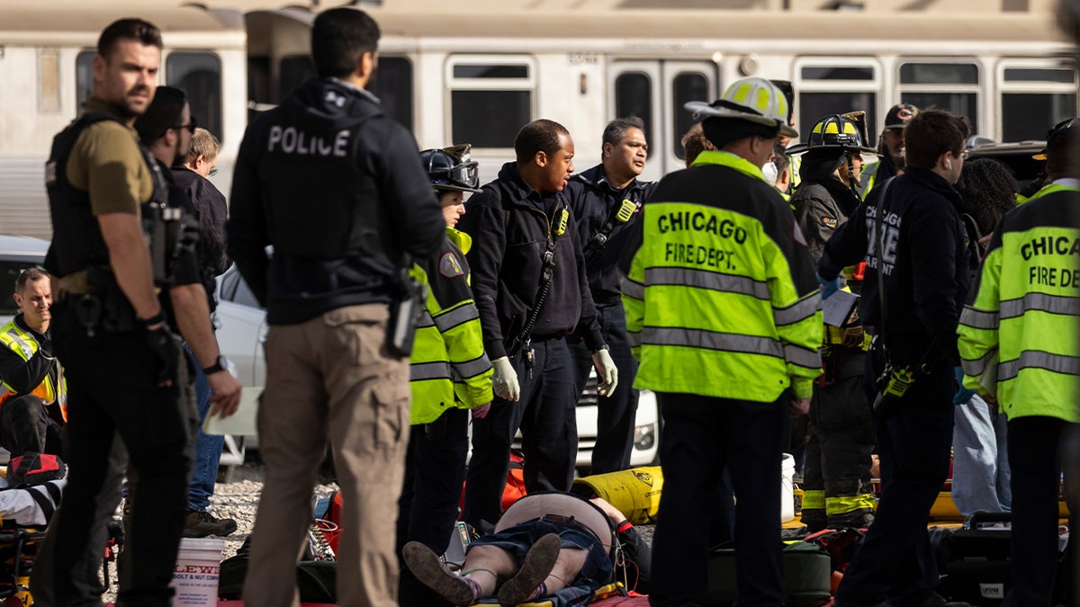 Man on the ground receiving treatment from paramedics