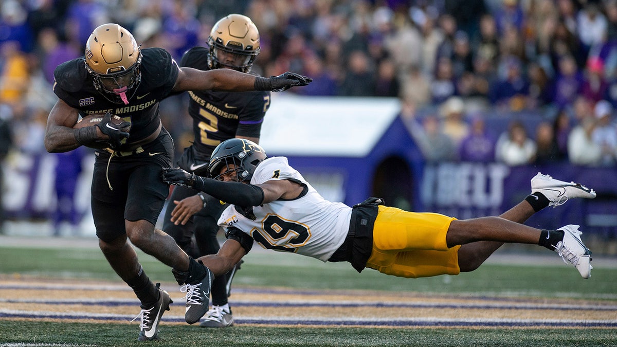 James Madison runs with the football